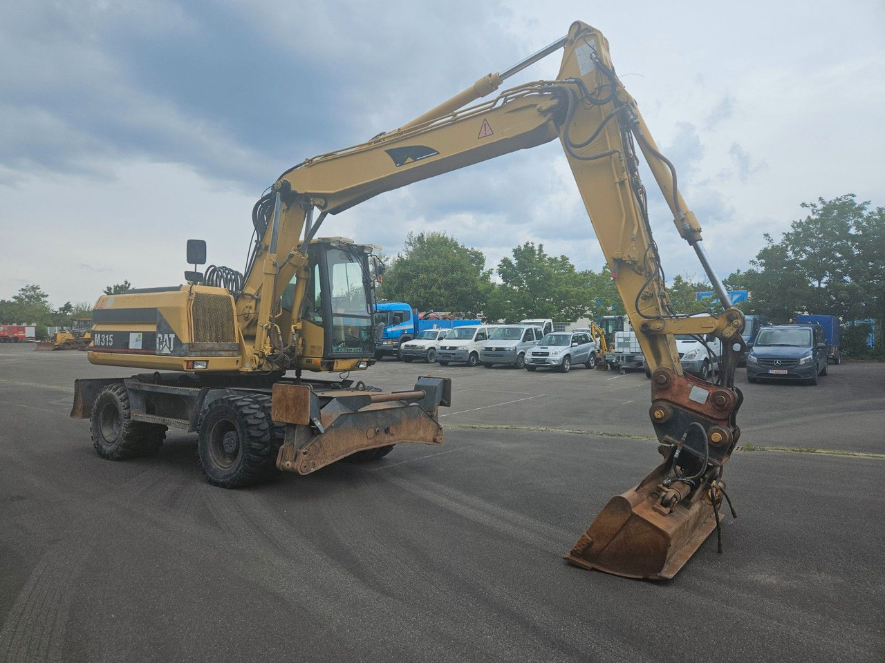 CAT M315 Mobilbagger mit Pratzen und Schild - Колесен багер: снимка 4 CAT M315 Mobilbagger mit Pratzen und Schild - Колесен багер: снимка 4